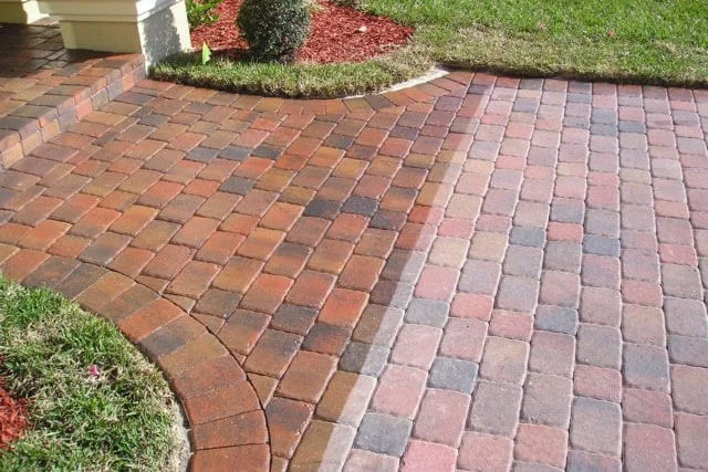 Freshly sealed brick paver driveway at a Satsuma, Alabama home showing rich color and a clean, water-resistant surface. The pavers are free of algae, joint weeds, and weather staining after professional sealing service by Lagniappe Soft Washing and Exterior Cleaning.