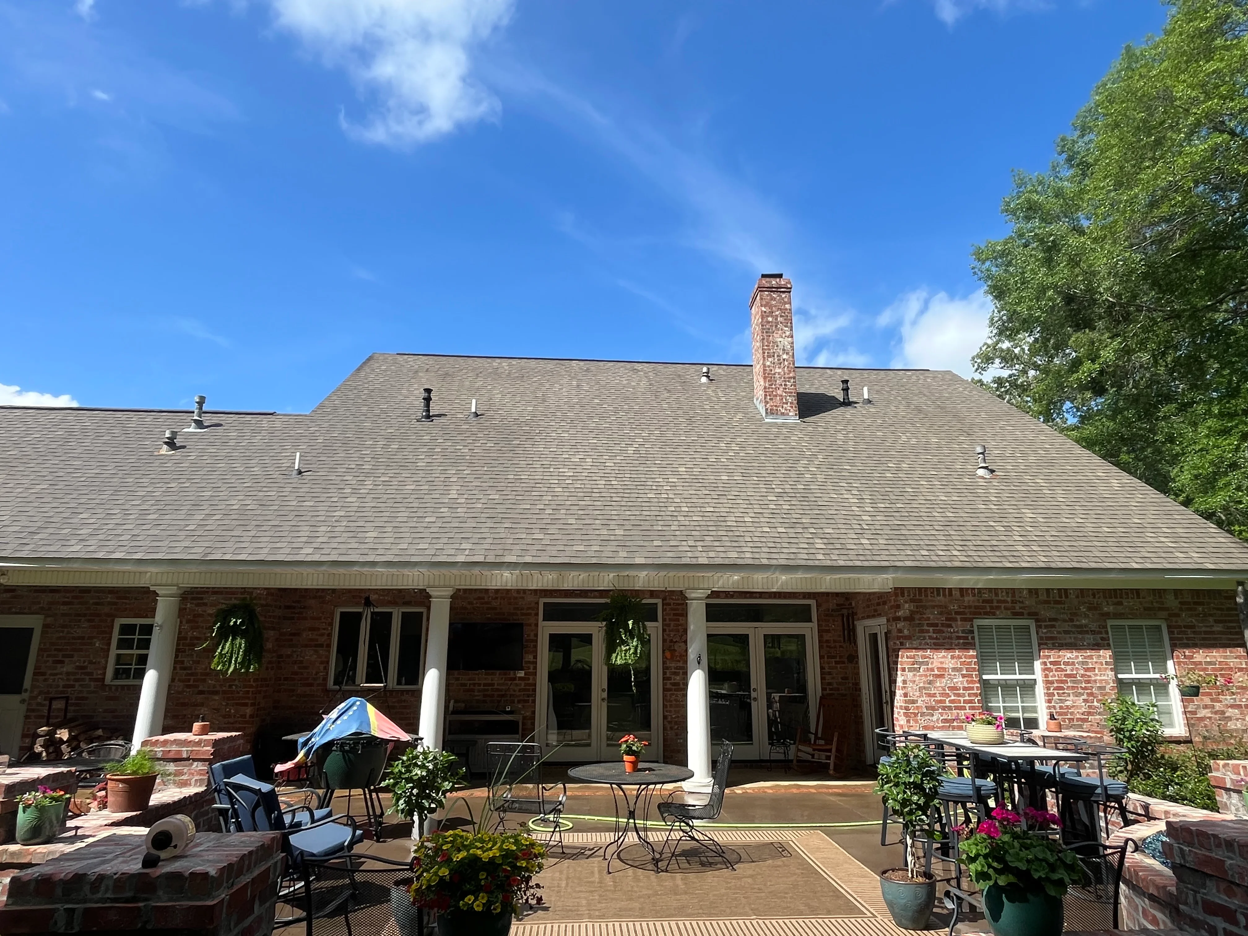 A Satsuma, Alabama home with a freshly soft-washed roof showing clean, streak-free asphalt shingles after algae and moss removal. The roofline is free of dark staining, with the cleaned surface visible against a clear Alabama sky.